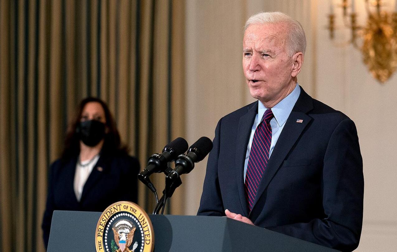 Biden speaking at podium and Karris behind him